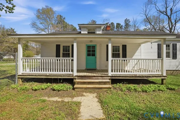 a view of a house with a small yard and wooden fence