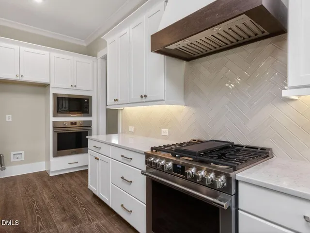 a kitchen with granite countertop stainless steel appliances and white cabinets