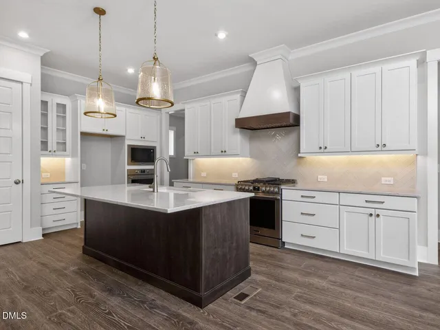 a kitchen with stainless steel appliances granite countertop a sink a stove and a refrigerator