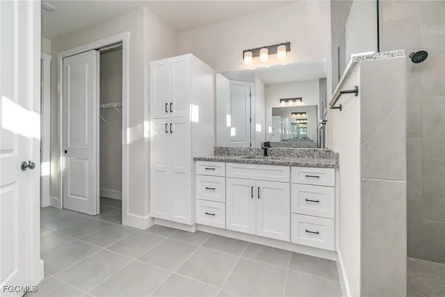 a spacious bathroom with a granite countertop sink mirror and shower