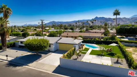 an aerial view of a house with a garden and lake view