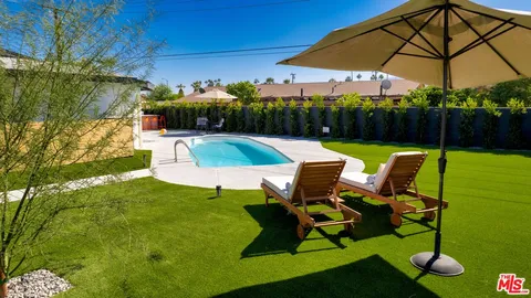 a view of a swimming pool with a patio and a garden