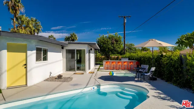 a view of a house with backyard sitting area and furniture