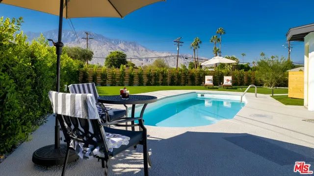a view of a patio with table and chairs under an umbrella