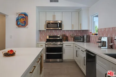 a kitchen with stainless steel appliances a stove a sink and a refrigerator