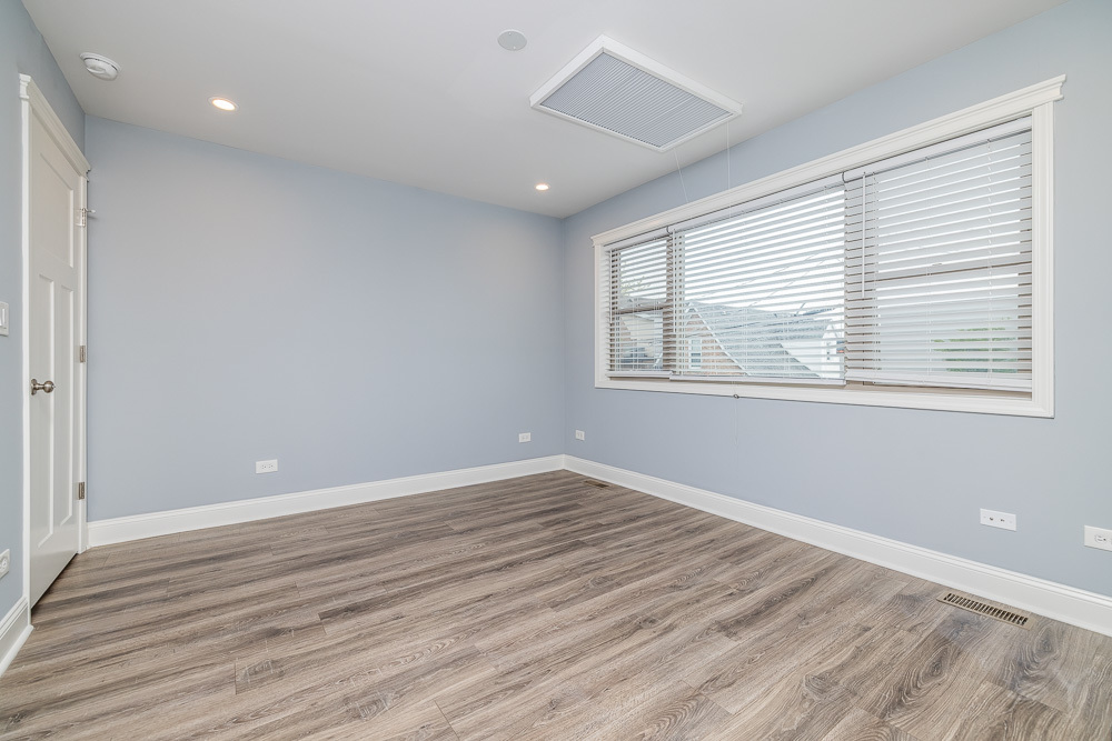 1300 South Heath Avenue Chicago, IL 60608 - Photo 44 of 55 a view of an empty room with wooden floor and a window
