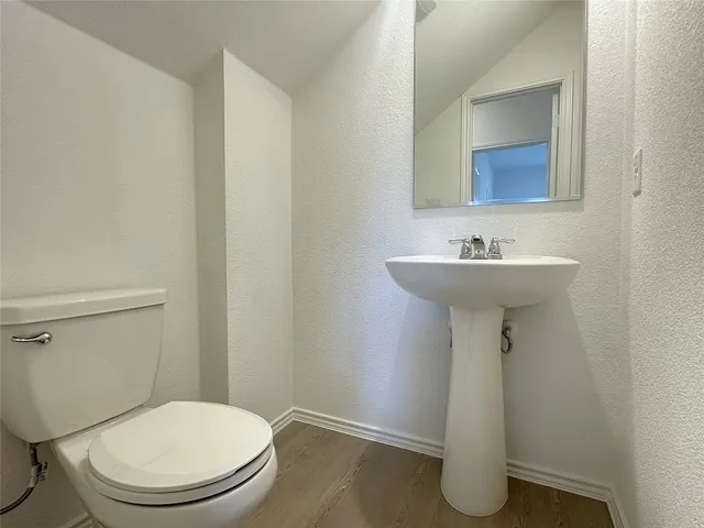 a bathroom with a sink toilet and mirror