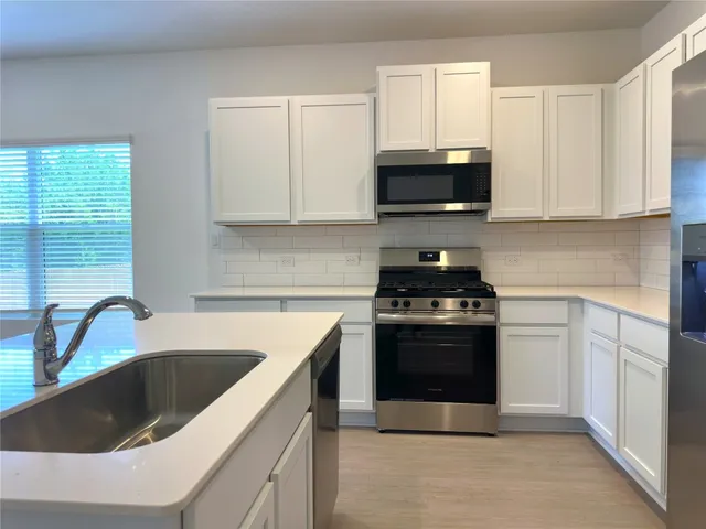 a kitchen with granite countertop a sink and a stove top oven
