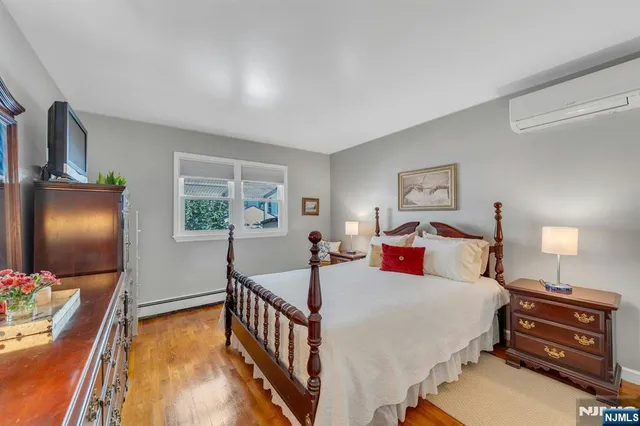 a bedroom with a bed and a flat tv screen on dresser