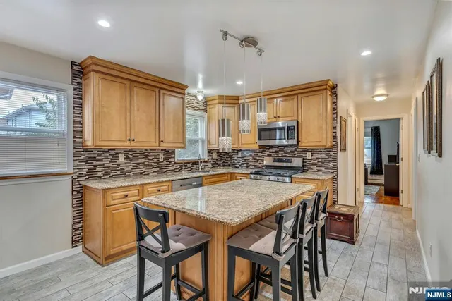a kitchen with stainless steel appliances granite countertop table chairs sink and stove