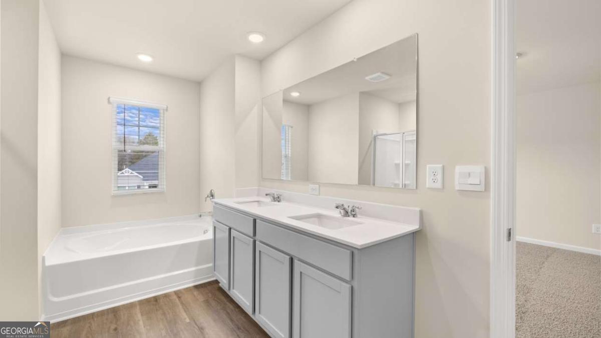 100 Planters Row Perry, GA 31069 - Photo 17 of 37 a bathroom with a sink a mirror and a bathtub