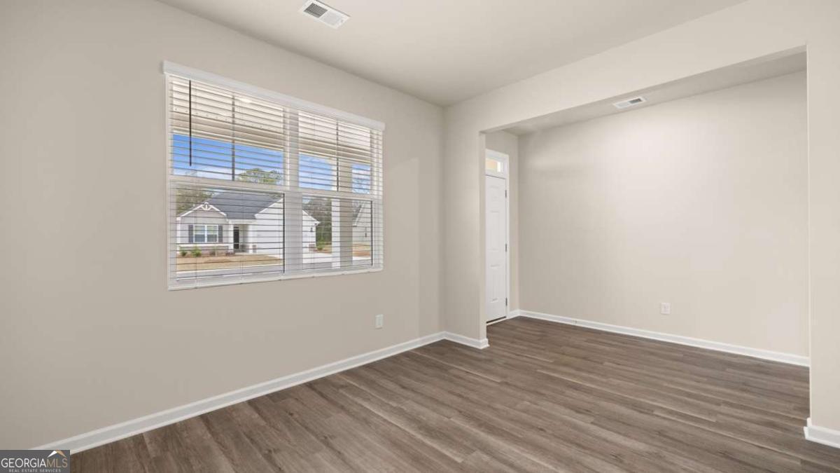 100 Planters Row Perry, GA 31069 - Photo 23 of 37 a view of an empty room with wooden floor and a window