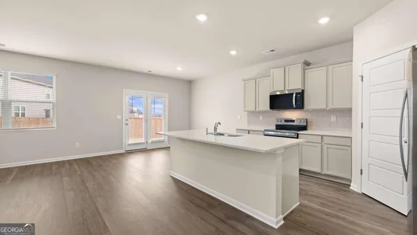 a kitchen with cabinets wooden floor and white appliances