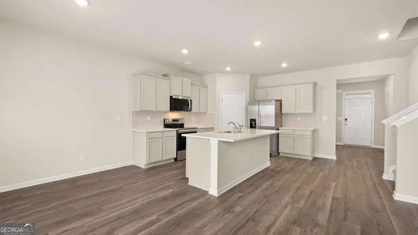 a kitchen with a sink a counter top space stainless steel appliances and cabinets