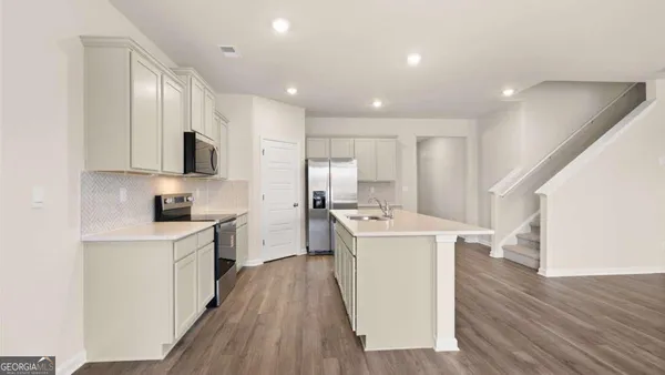 a kitchen with stainless steel appliances a sink and a refrigerator