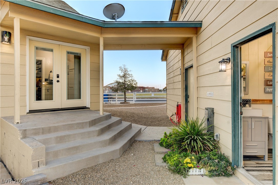 6460 Racel Street Las Vegas, NV 89131 - Photo 21 of 59 Concrete steps ascend to a covered entryway flanked by horizontal siding.