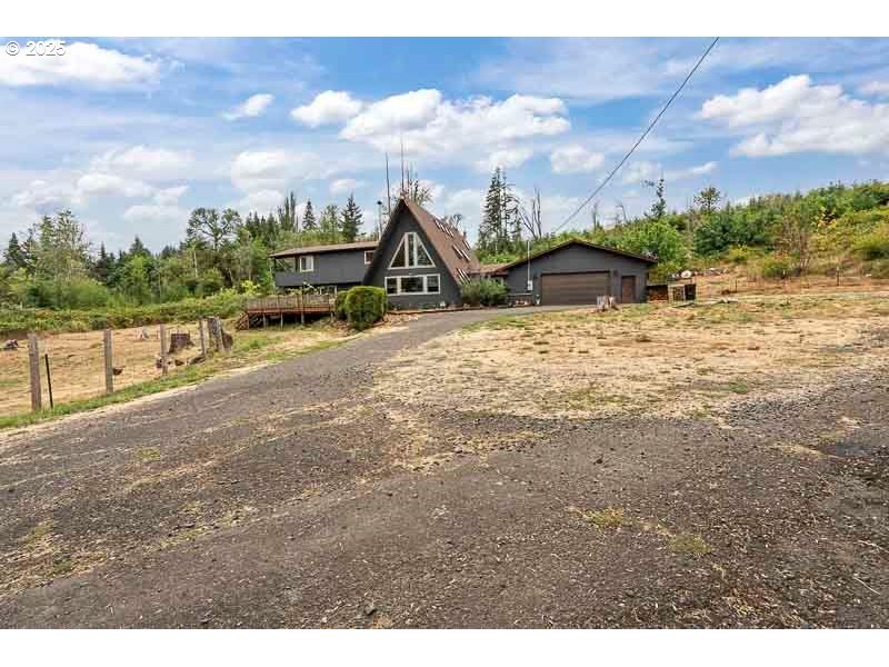 a view of a dry yard with wooden fence