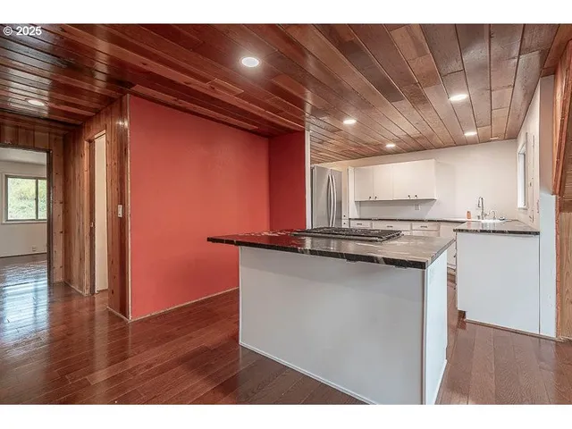 a kitchen with stainless steel appliances granite countertop a sink and wooden cabinets