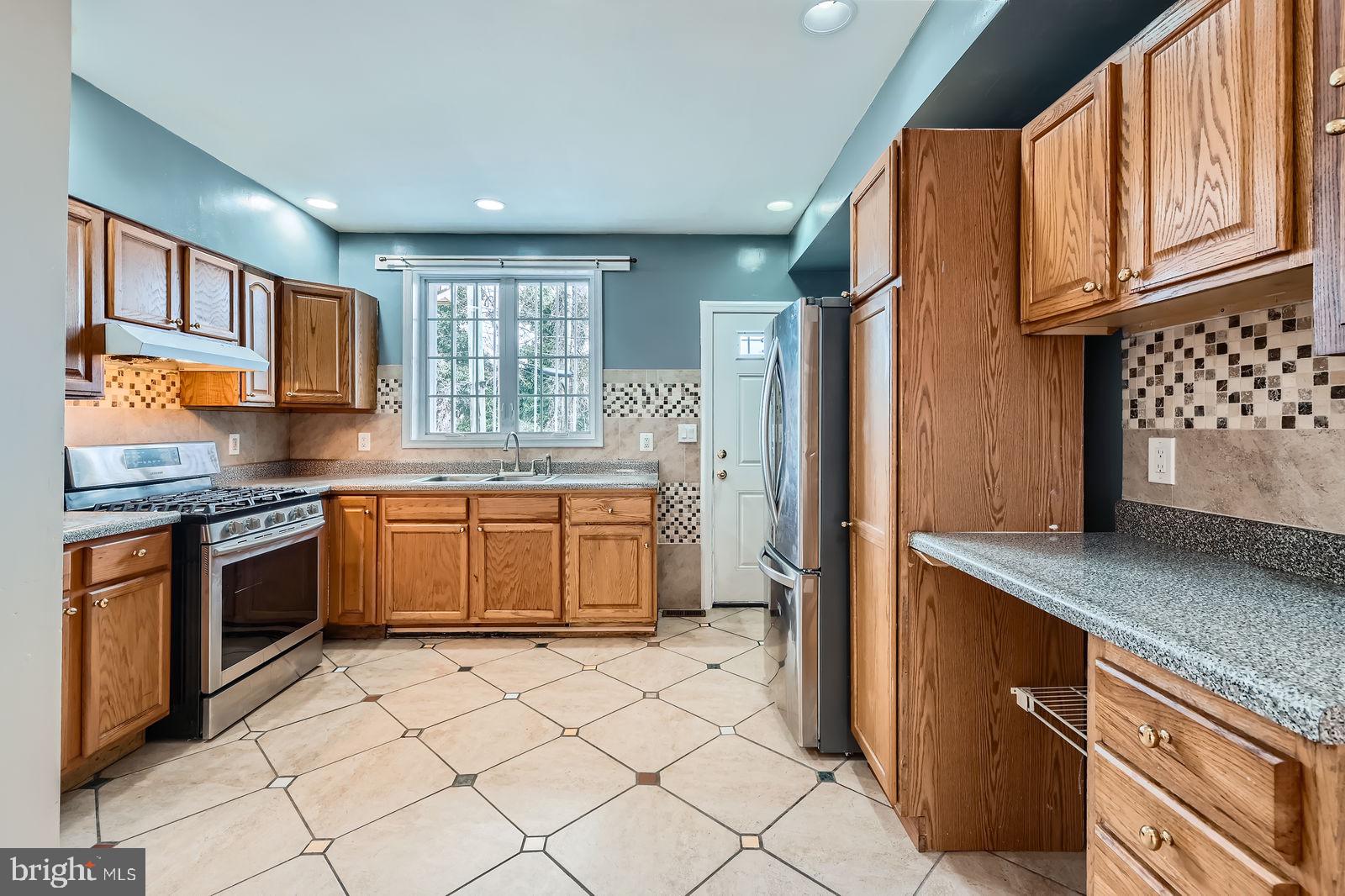 2015 East North Avenue Baltimore, MD 21213 - Photo 11 of 34 a kitchen with stainless steel appliances granite countertop a stove a sink and a refrigerator