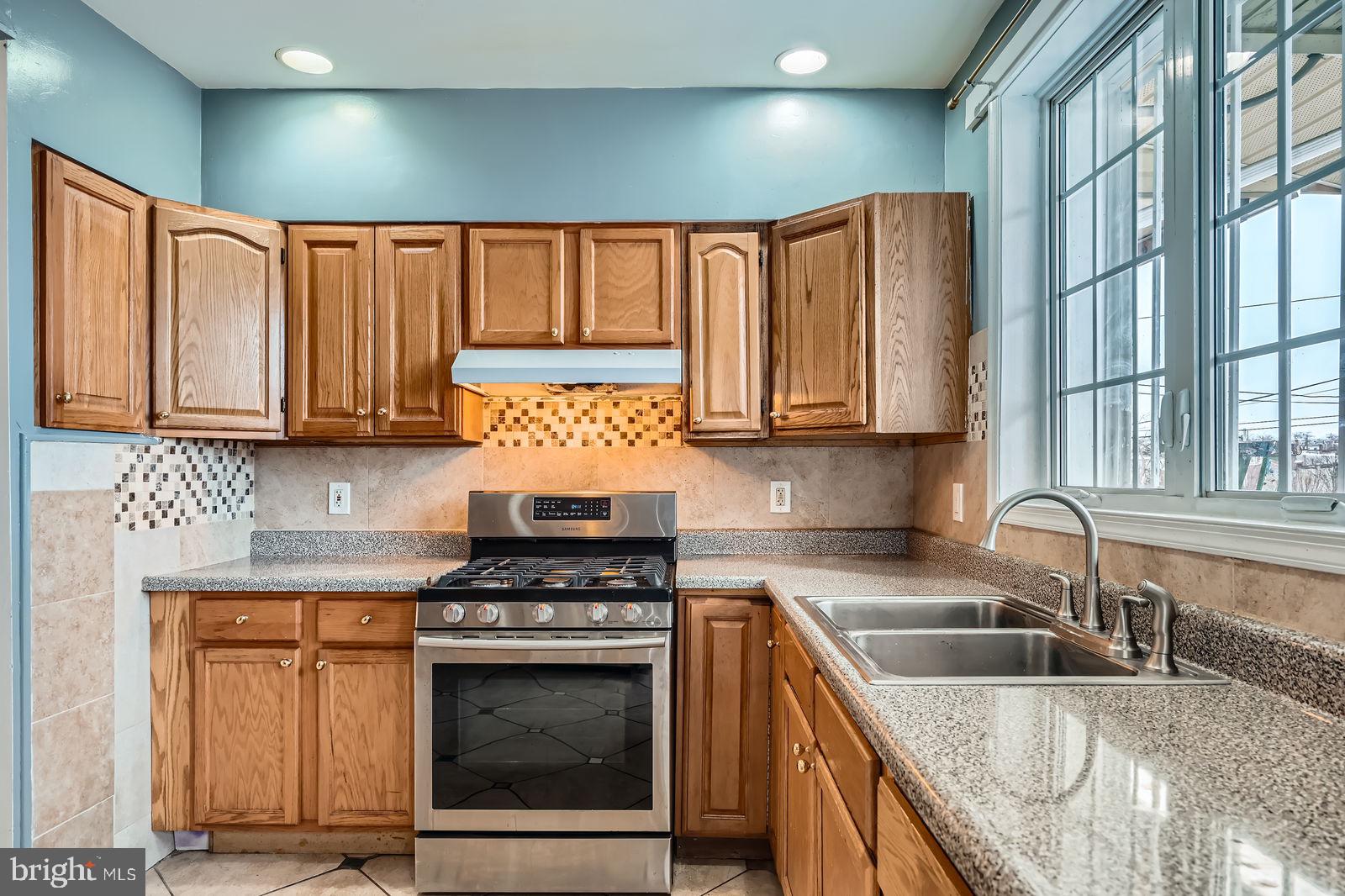 2015 East North Avenue Baltimore, MD 21213 - Photo 13 of 34 a kitchen with stainless steel appliances granite countertop a stove a sink and a microwave
