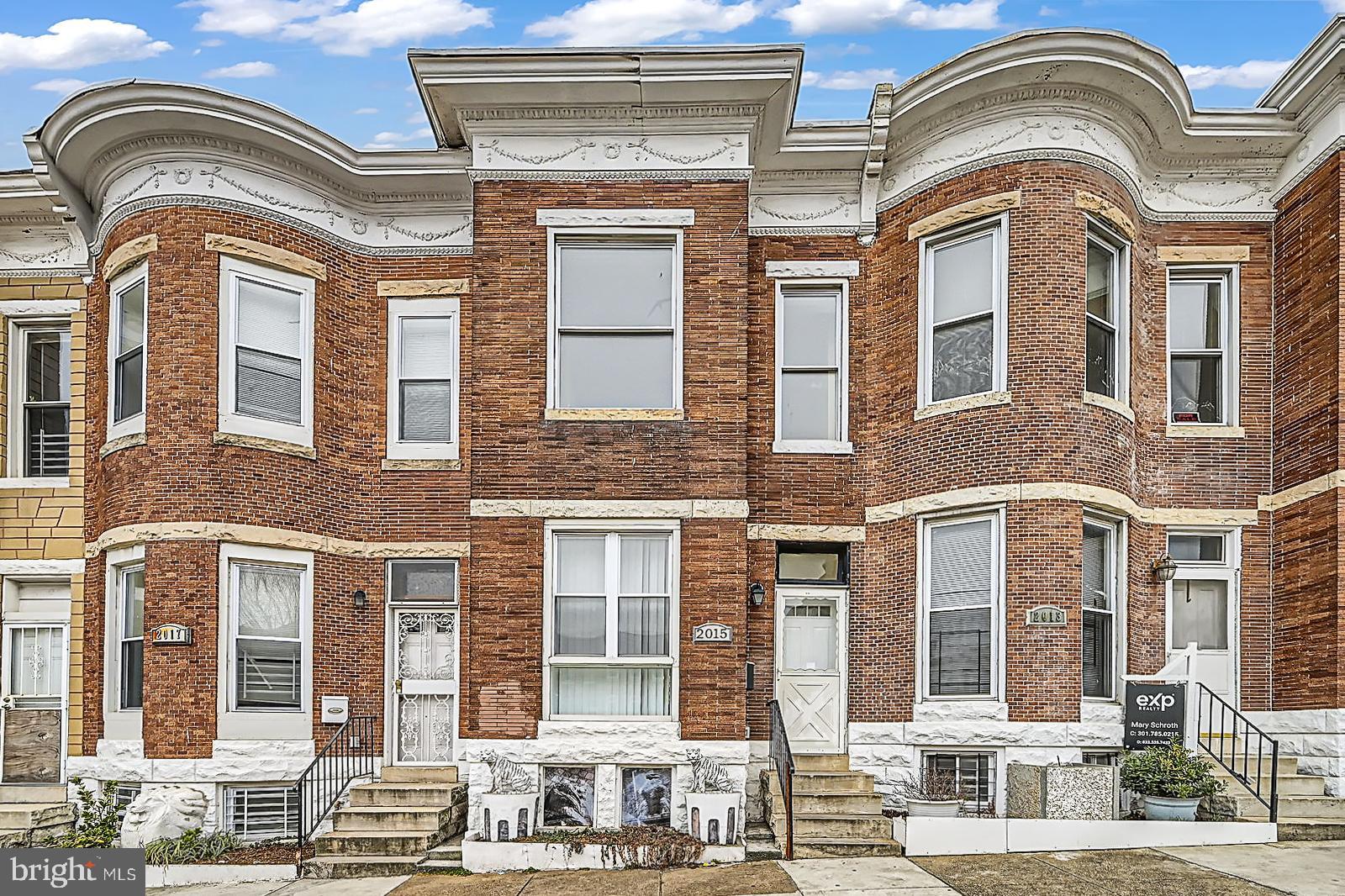 2015 East North Avenue Baltimore, MD 21213 - Photo 2 of 34 a front view of a residential apartment building with a yard