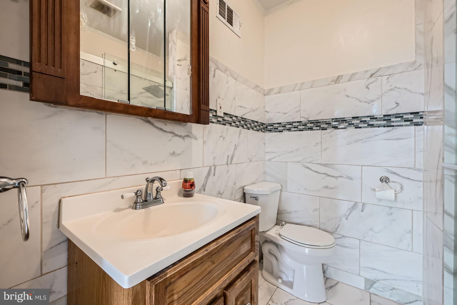 2015 East North Avenue Baltimore, MD 21213 - Photo 21 of 34 a bathroom with a sink a toilet and mirror