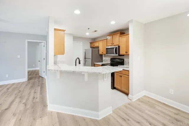 a kitchen with kitchen island a counter top space a sink a stove a refrigerator and a window