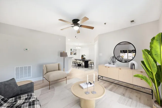 a living room with furniture a mirror and a table