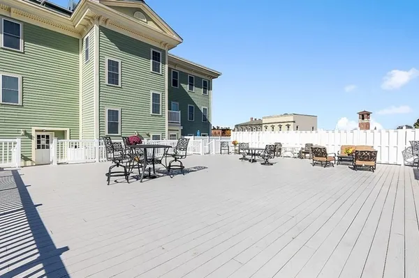 a view of a patio with dining table and chairs with wooden floor