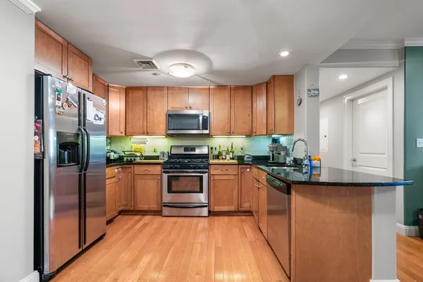 a kitchen with granite countertop stainless steel appliances and wooden cabinets