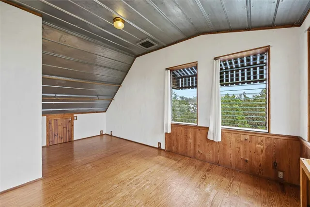 a view of a hallway with wooden floor and furniture
