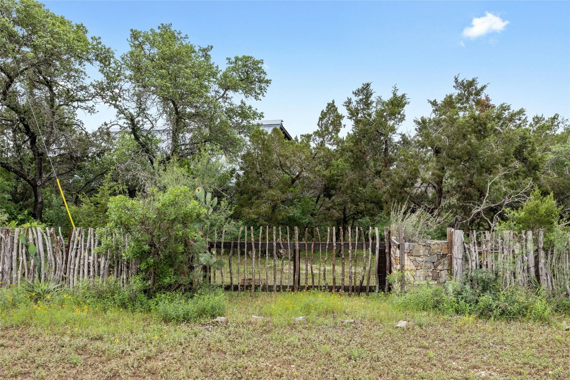 15207 Farm To Market Road 2769 Volente, TX 78641 - Photo 6 of 26 a garden with trees in front of it