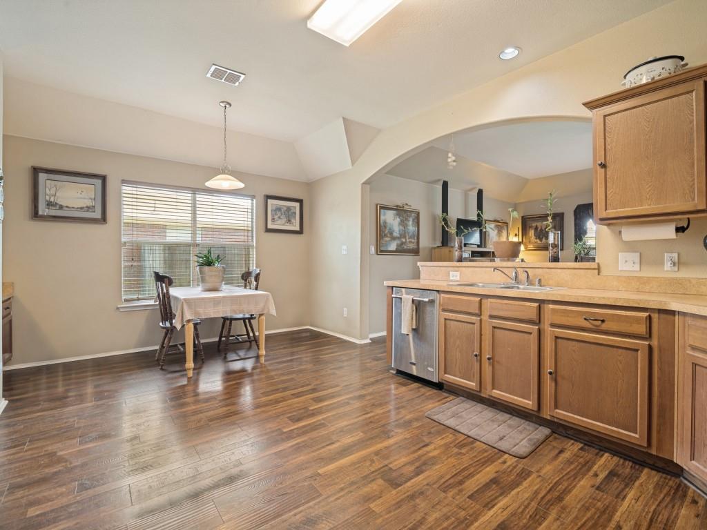 119 Robin Lane Forney, TX 75126 - Photo 11 of 27 Kitchen dining area featuring wood-finish flooring, a vaulted ceiling, and an arched doorway