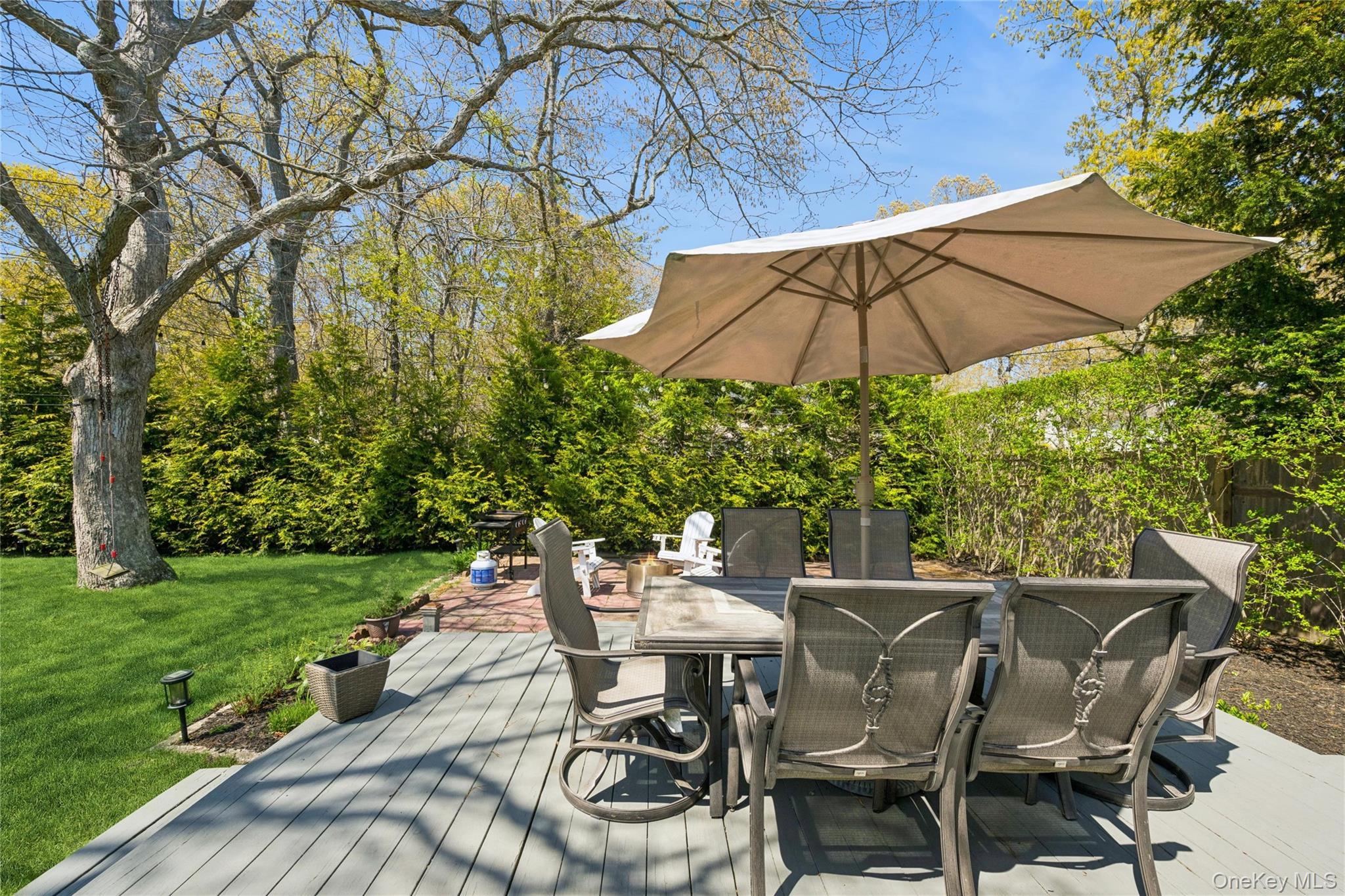 57 Kyle Road Hampton Bays, NY 11946 - Photo 16 of 19 a view of a patio with table and chairs under an umbrella