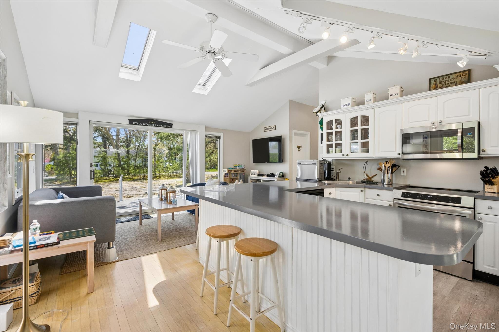 57 Kyle Road Hampton Bays, NY 11946 - Photo 6 of 19 a large white kitchen with lots of counter space and windows
