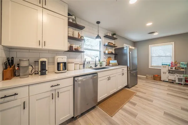 a kitchen with white cabinets and sink