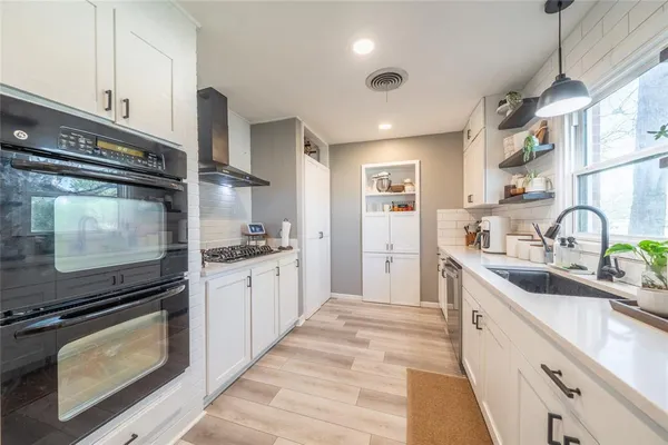 a kitchen with stainless steel appliances a stove sink and cabinets