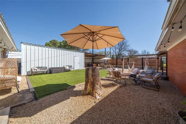 a patio with a table and chairs under an umbrella