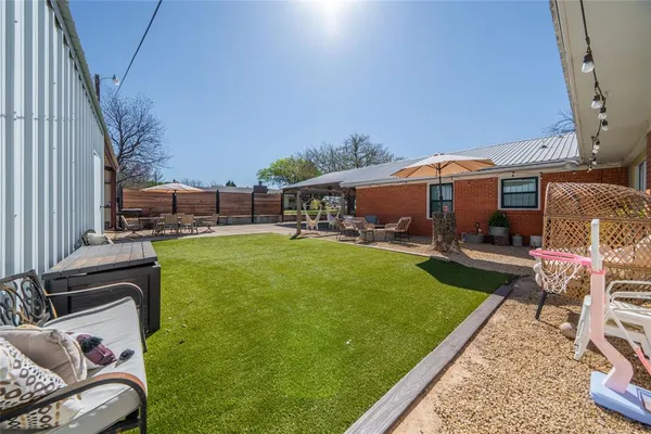 a view of a patio with couches chairs and a big yard