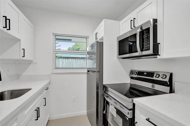 a kitchen with stainless steel appliances granite countertop a sink stove and microwave