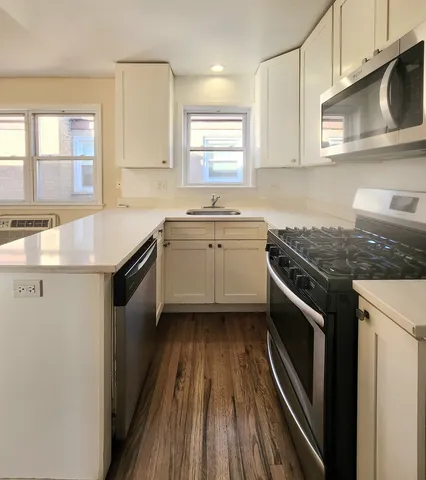 a kitchen with granite countertop a sink stove and cabinets