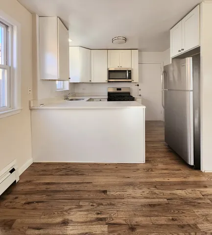 a kitchen with wooden cabinets and refrigerator