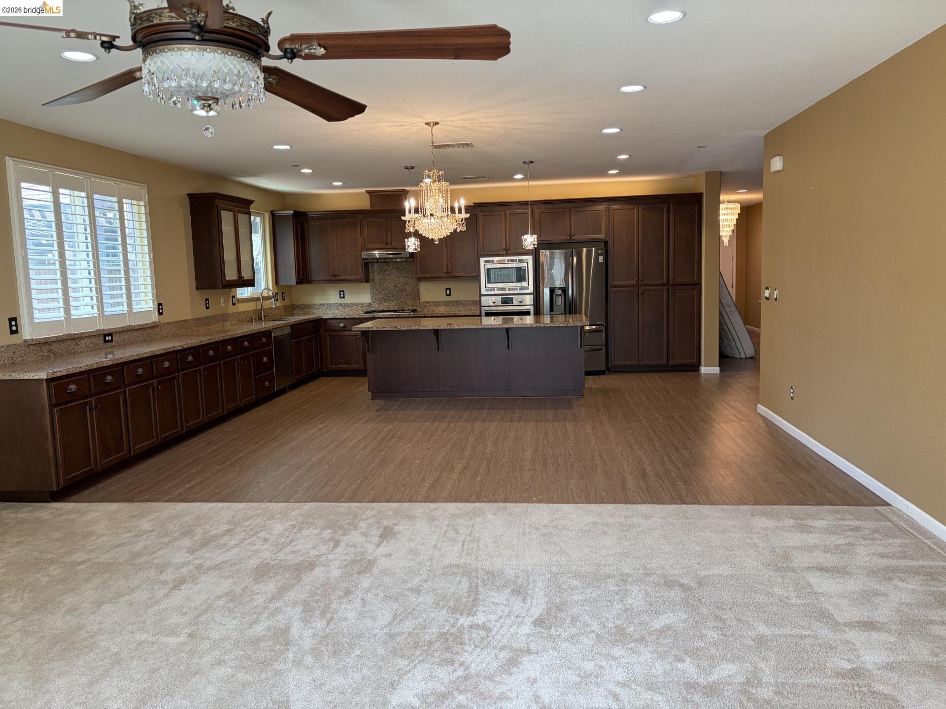 809 Ibis Road Oakley, CA 94561 - Photo 22 of 32 Kitchen featuring dark wood-finish cabinetry, light-toned countertops, and a center island