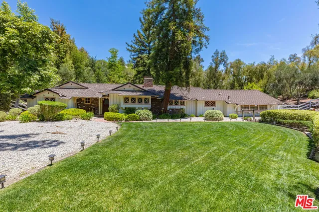 a front view of a house with yard and green space
