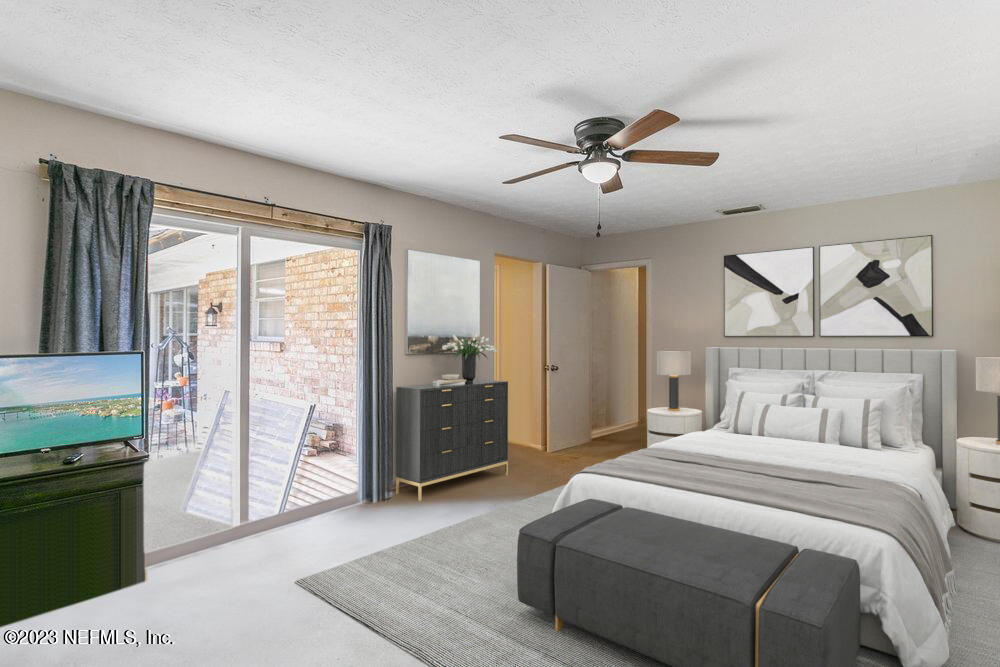 1807 Mill Creek Road Jacksonville, FL 32277 - Photo 12 of 18 a spacious bedroom with a large bed and a chandelier