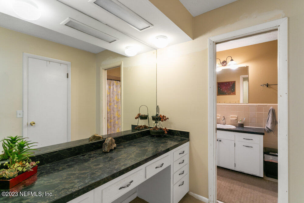 1807 Mill Creek Road Jacksonville, FL 32277 - Photo 13 of 18 a bathroom with a granite countertop sink and a mirror