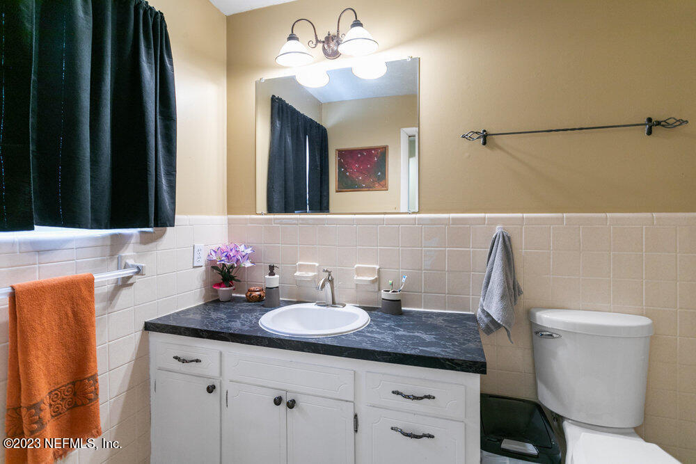 1807 Mill Creek Road Jacksonville, FL 32277 - Photo 14 of 18 a bathroom with a granite countertop sink vanity mirror and toilet