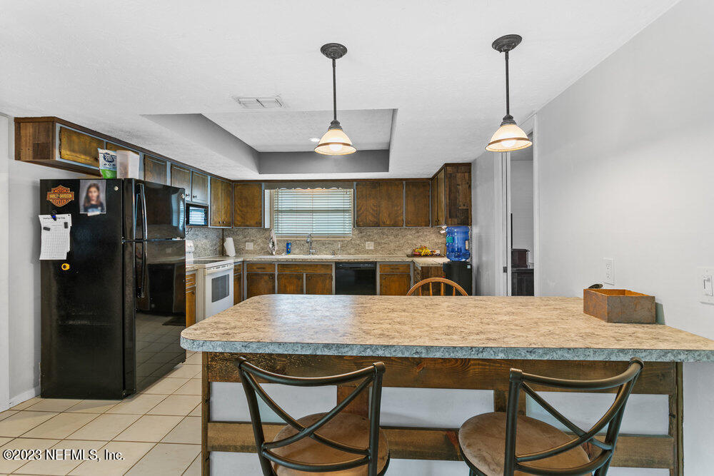1807 Mill Creek Road Jacksonville, FL 32277 - Photo 6 of 18 a kitchen with stainless steel appliances kitchen island granite countertop a kitchen island and chairs in it