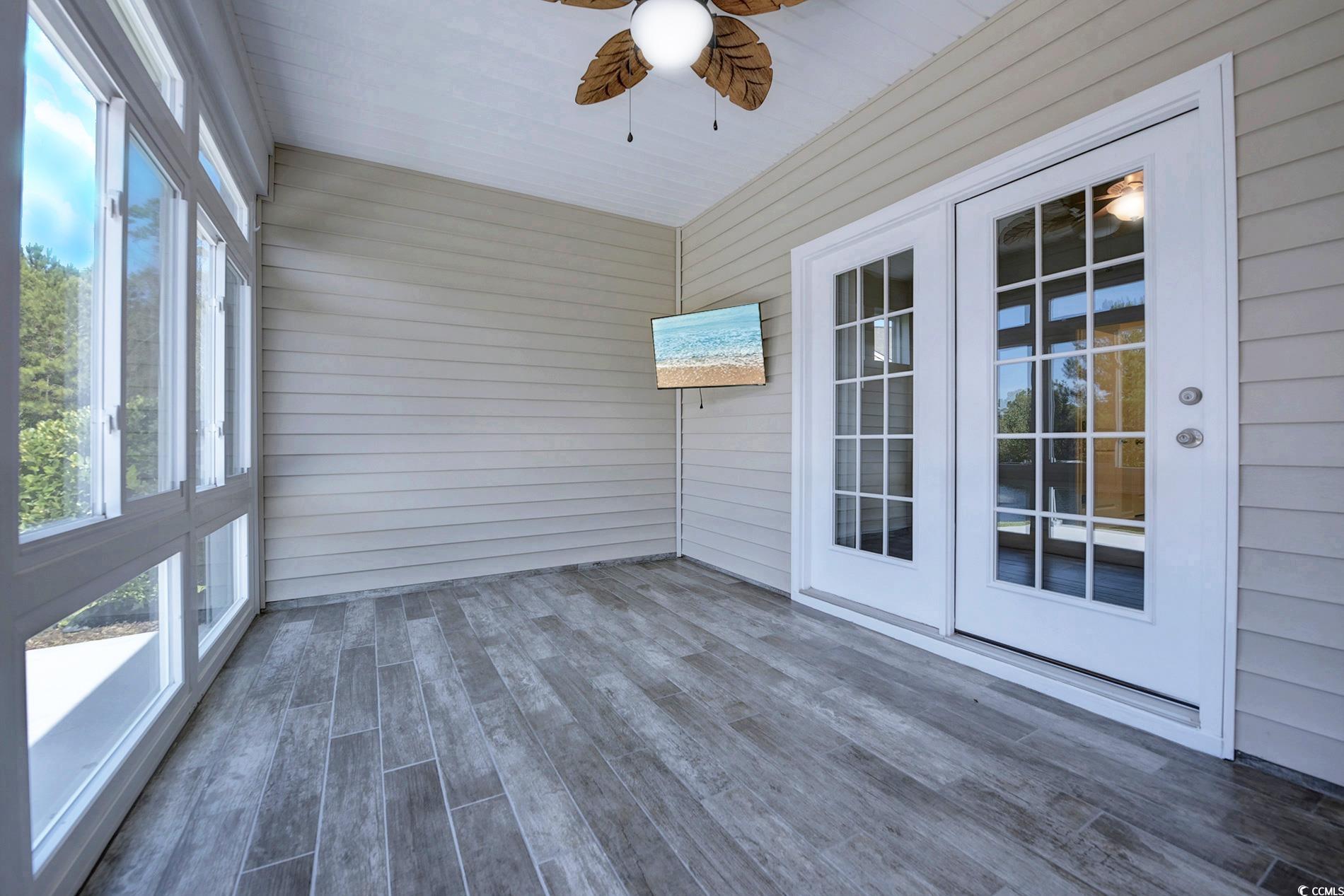 108 Parmelee Drive, Unit E Murrells Inlet, SC 29576 - Photo 15 of 40 Unfurnished sunroom with a ceiling fan, wooden walls, and wood finished floors