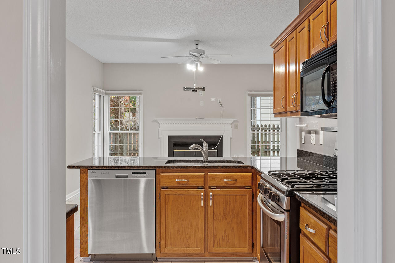 11932 North Exeter Way Raleigh, NC 27613 - Photo 15 of 35 a kitchen with a stove and a microwave